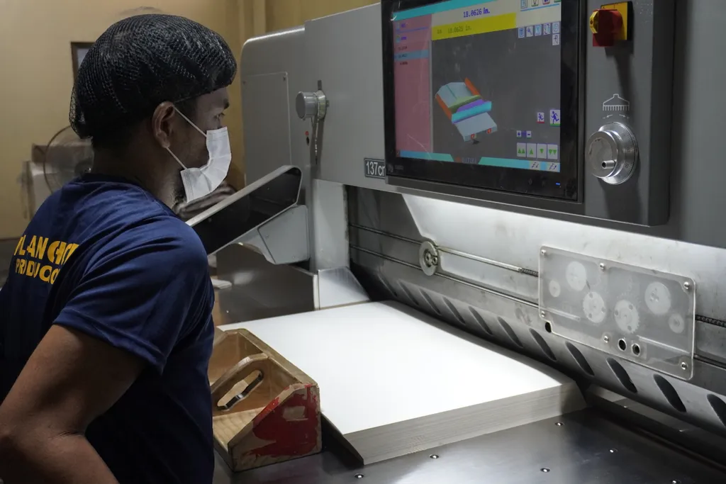 Fil-Anchor staff inspecting paper stock at the cutting machine